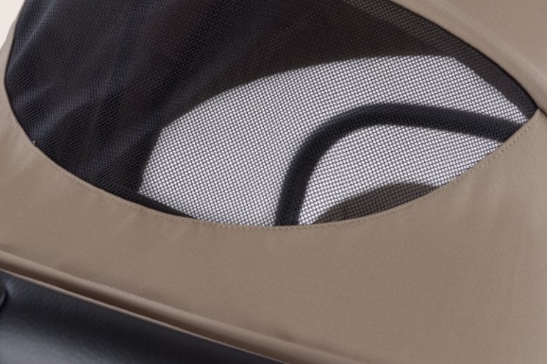 Close up of a beige stroller hood featuring black mesh window, showcasing the stroller's design and ventilation feature.
