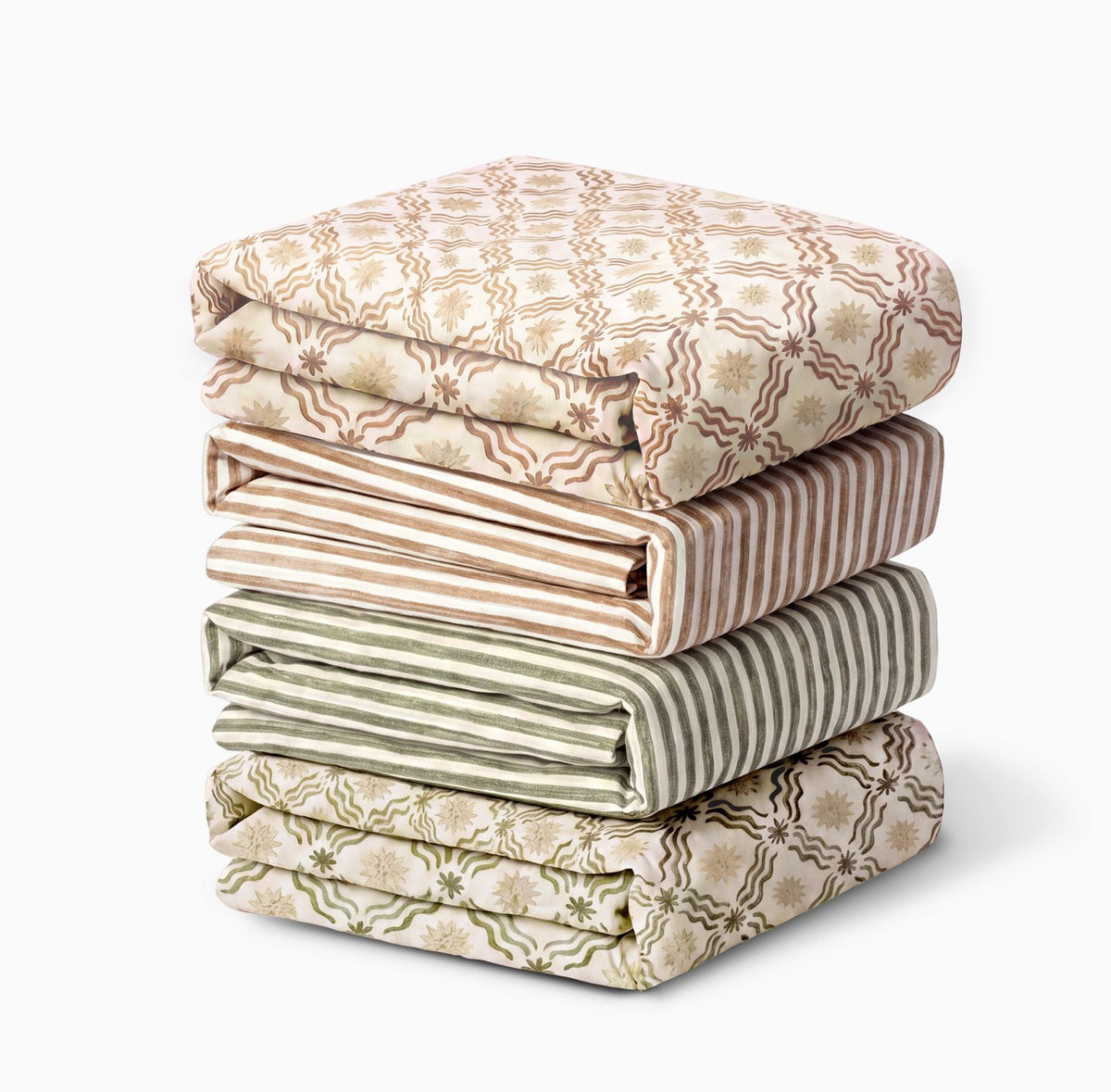 Stack of four folded Babyletto crib sheets with floral and striped patterns