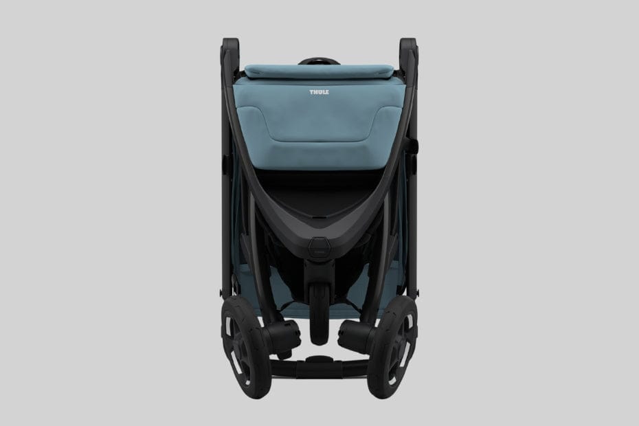 Light blue and black Thule stroller viewed from rear, compact folded design with large wheels, neutral background.