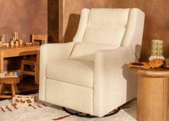 Cream colored upholstered swivel glider chair in a nursery setting