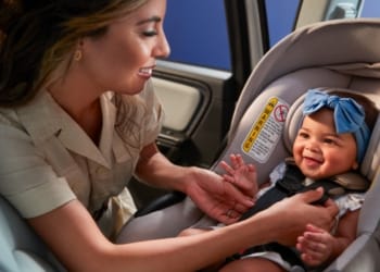 Woman securing a baby in a car seat
