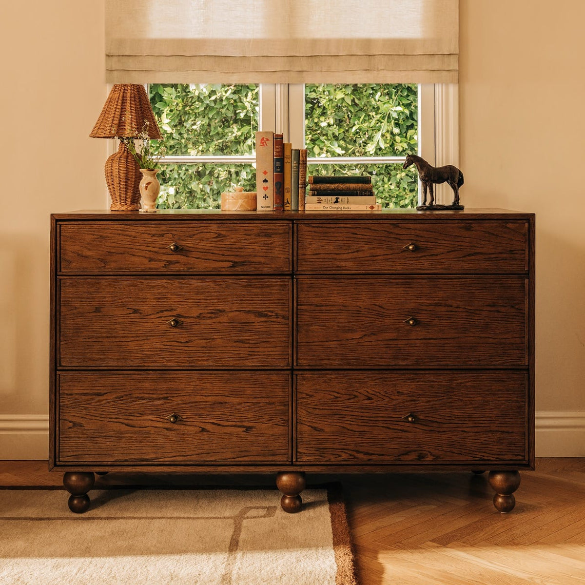Babyletto six drawer wooden dresser with round feet and brass hardware