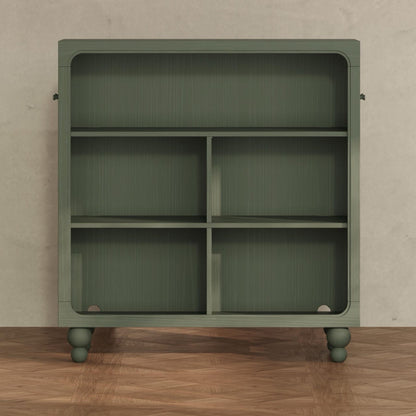 Babyletto green wooden bookshelf with four storage compartments and rounded feet