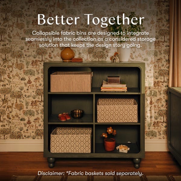 Babyletto dark green wooden bookshelf with patterned fabric storage bins on shelves