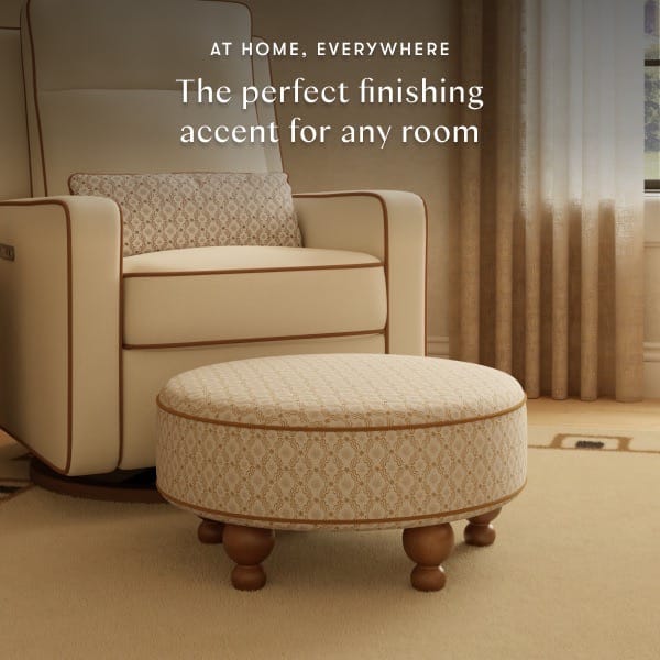 Babyletto round patterned ottoman with wooden feet in front of a matching armchair