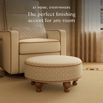 Babyletto round patterned ottoman with wooden feet in front of a matching armchair