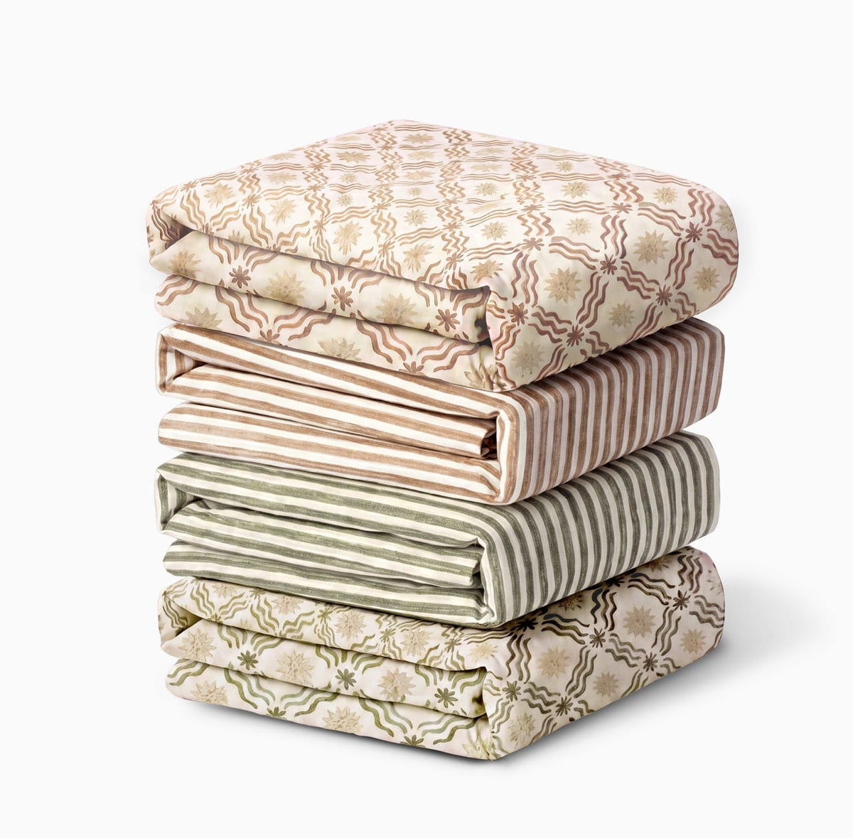 Stack of four folded Babyletto crib sheets with floral and striped patterns