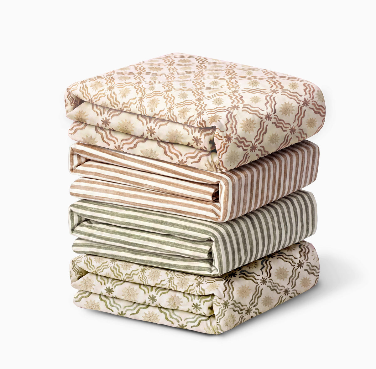 Stack of four folded Babyletto crib sheets with floral and striped patterns