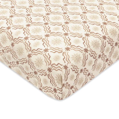 Babyletto crib sheet with brown wavy lines and star pattern on cream fabric