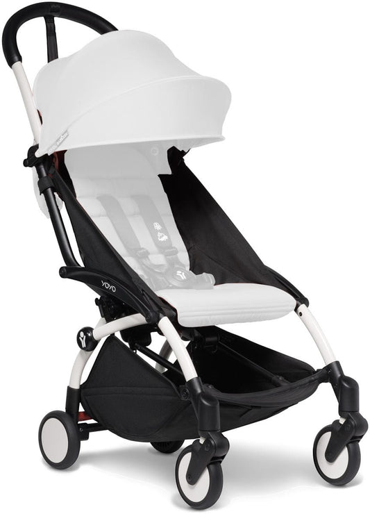 White Babyzen YOYO2 ultra compact stroller frame with black accents, white canopy, and four wheels, front three-quarter view