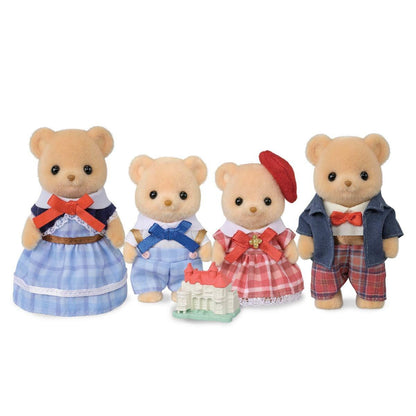 Four Calico Critters bear figures in outfits with a small toy castle