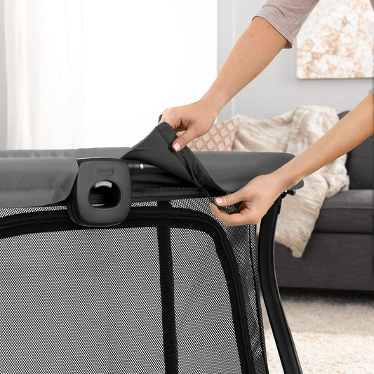 Midnight blue lightweight travel playard by Chicco with mesh sides, black frame, and padded top rail, front view