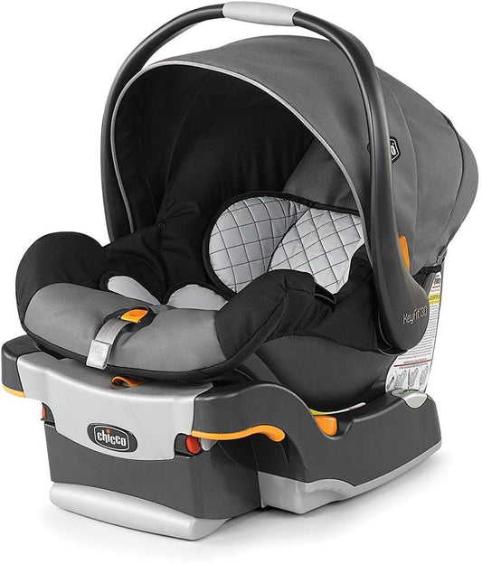 Gray and black infant car seat with quilted headrest and orange accents by Chicco, shown from front three-quarter view with canopy open
