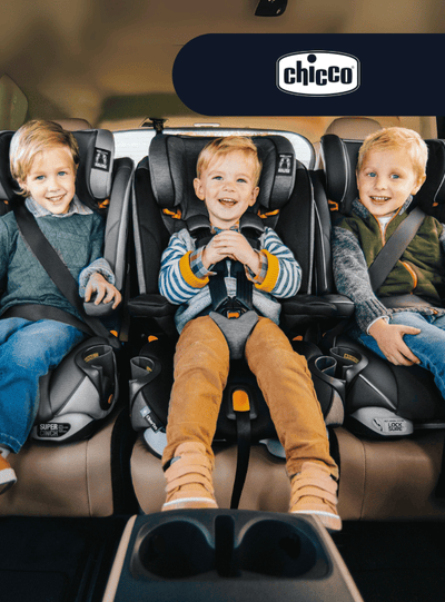 Three smiling children in Chicco car seats, secured with harnesses, seated side-by-side in a vehicle.