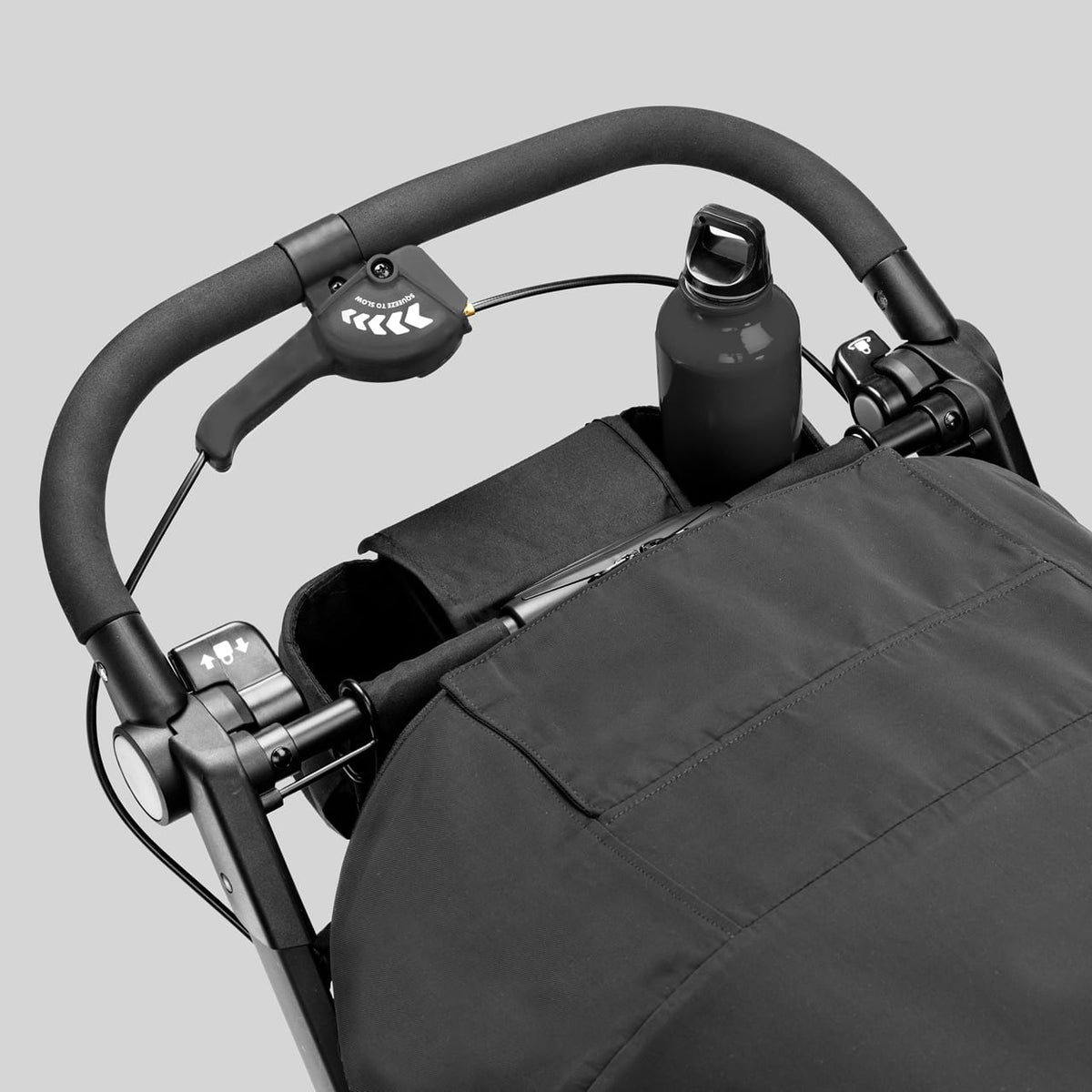 Black stroller handlebar with integrated hand brake and bottle holder