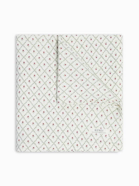 Colored Organics white blanket with green trellis pattern and small pink flower buds