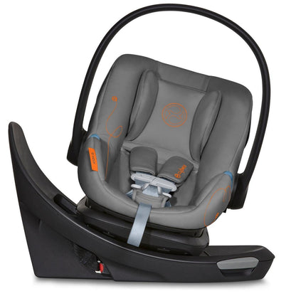 Lava grey infant car seat with orange stitching and black frame by Cybex, featuring swivel base and SensorSafe technology, side view