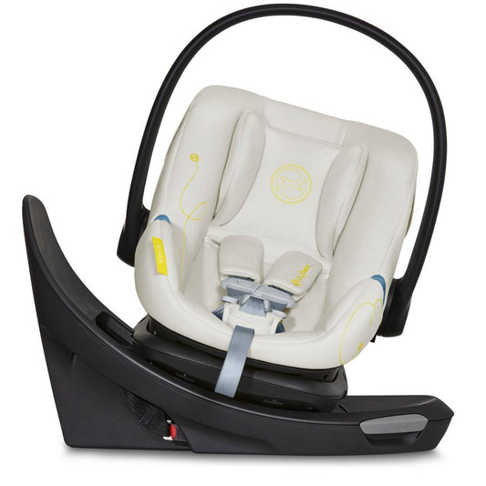 Seashell beige infant car seat by Cybex with yellow stitching, black frame, and rotating base, front view