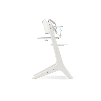 Side view of a white wooden Nomi high chair with a tray and safety harness