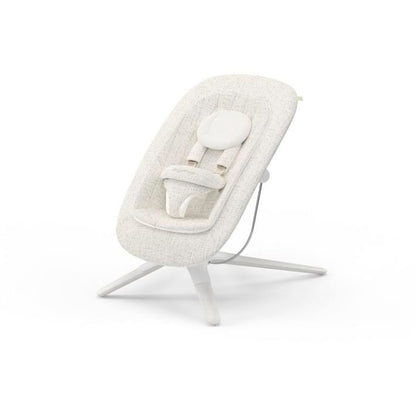 Cream colored baby bouncer with white frame and safety harness