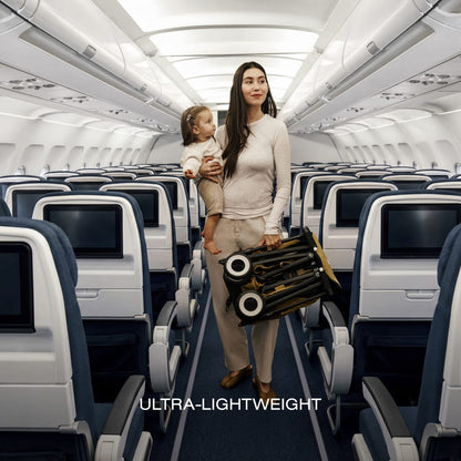Woman carrying a toddler and a folded Cybex travel stroller down an airplane aisle
