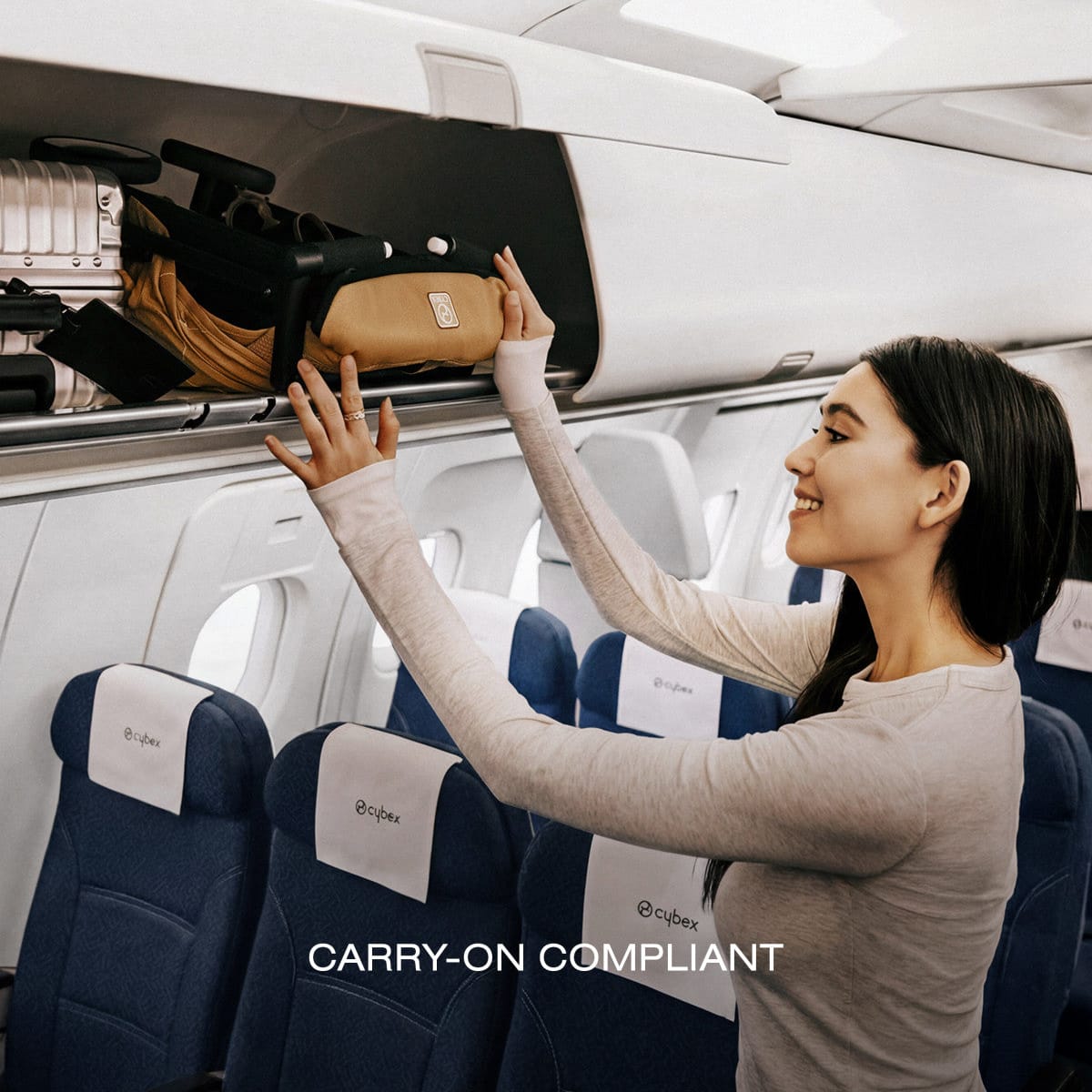 Woman placing a folded Cybex stroller into an airplane overhead bin
