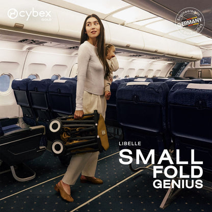 Woman holding a folded Cybex Libelle stroller while carrying a child in an airplane aisle