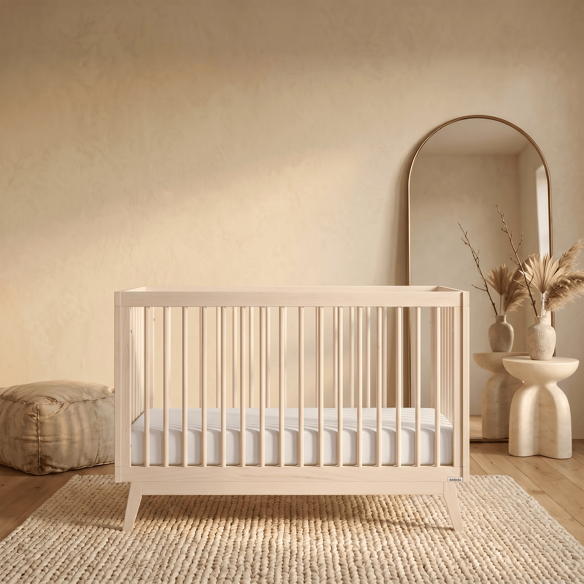 Dadada wooden crib with white mattress on a textured rug in a neutral room