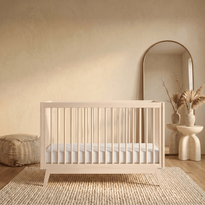 Dadada wooden crib with white mattress on a textured rug in a neutral room