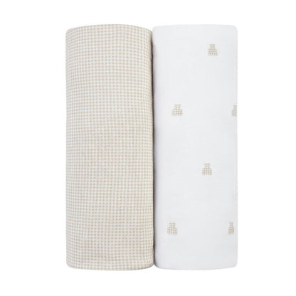 Two rolled Ely's & Co swaddle blankets one with beige gingham and one white with small beige bear icons