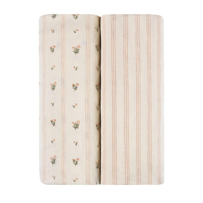 Ely's & Co two folded baby crib sheets with floral and striped patterns on cream fabric