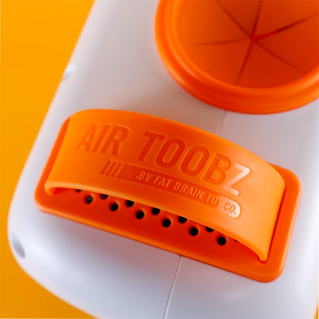 Orange silicone handle on white Fat Brain Toys Air Toobz device