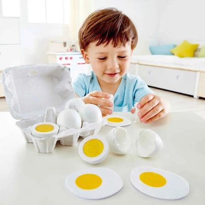 Child playing with Hape wooden egg set on a table