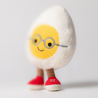 Jellycat plush toy shaped like a hard boiled egg with embroidered glasses and red sneakers