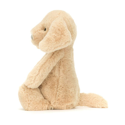Jellycat beige plush dog toy in a seated side profile