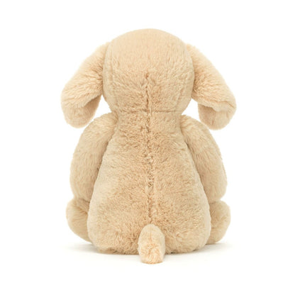 Back view of a beige Jellycat plush dog toy with floppy ears and a small tail