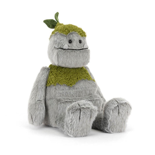 Jellycat grey plush monster with green mossy patches and a leaf on its head