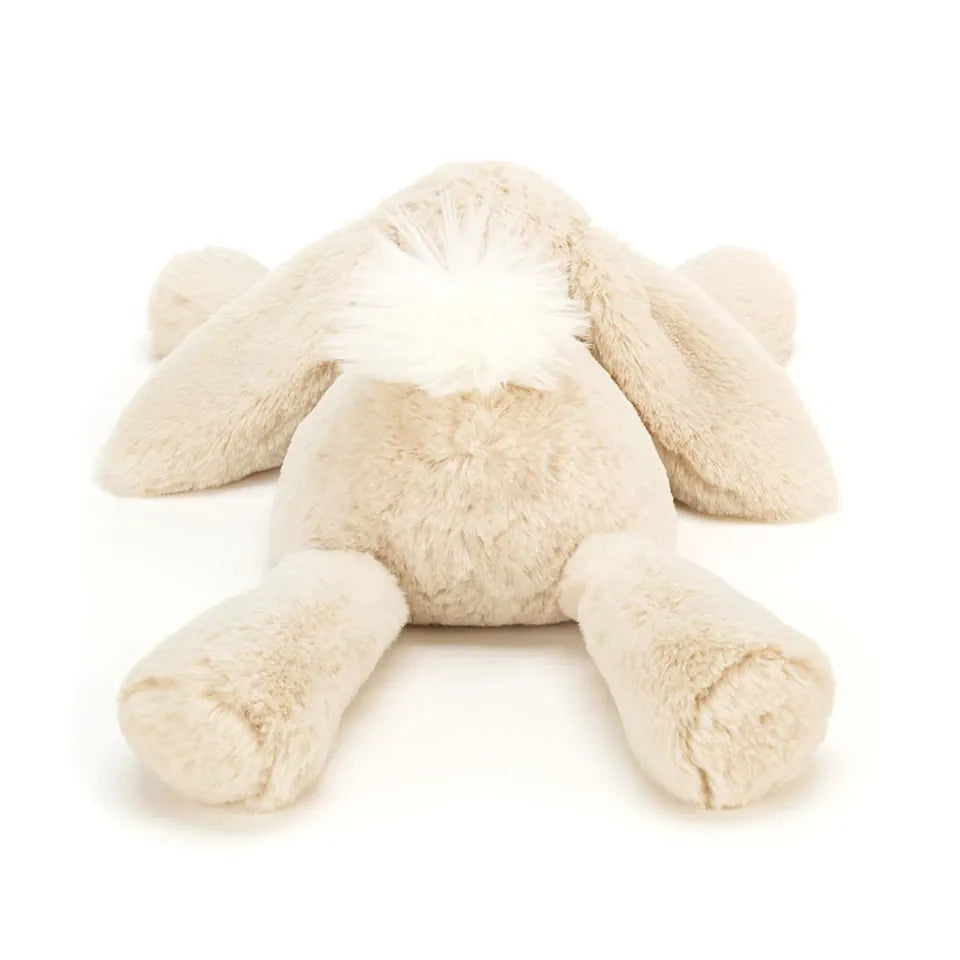 Beige plush bunny toy viewed from behind with a white fluffy tail