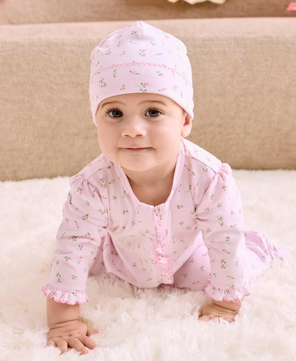 Baby wearing a Kissy Kissy pink floral print footie and matching hat