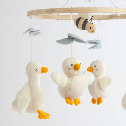 Living Textiles baby mobile with plush ducklings and a bee hanging from a wooden frame