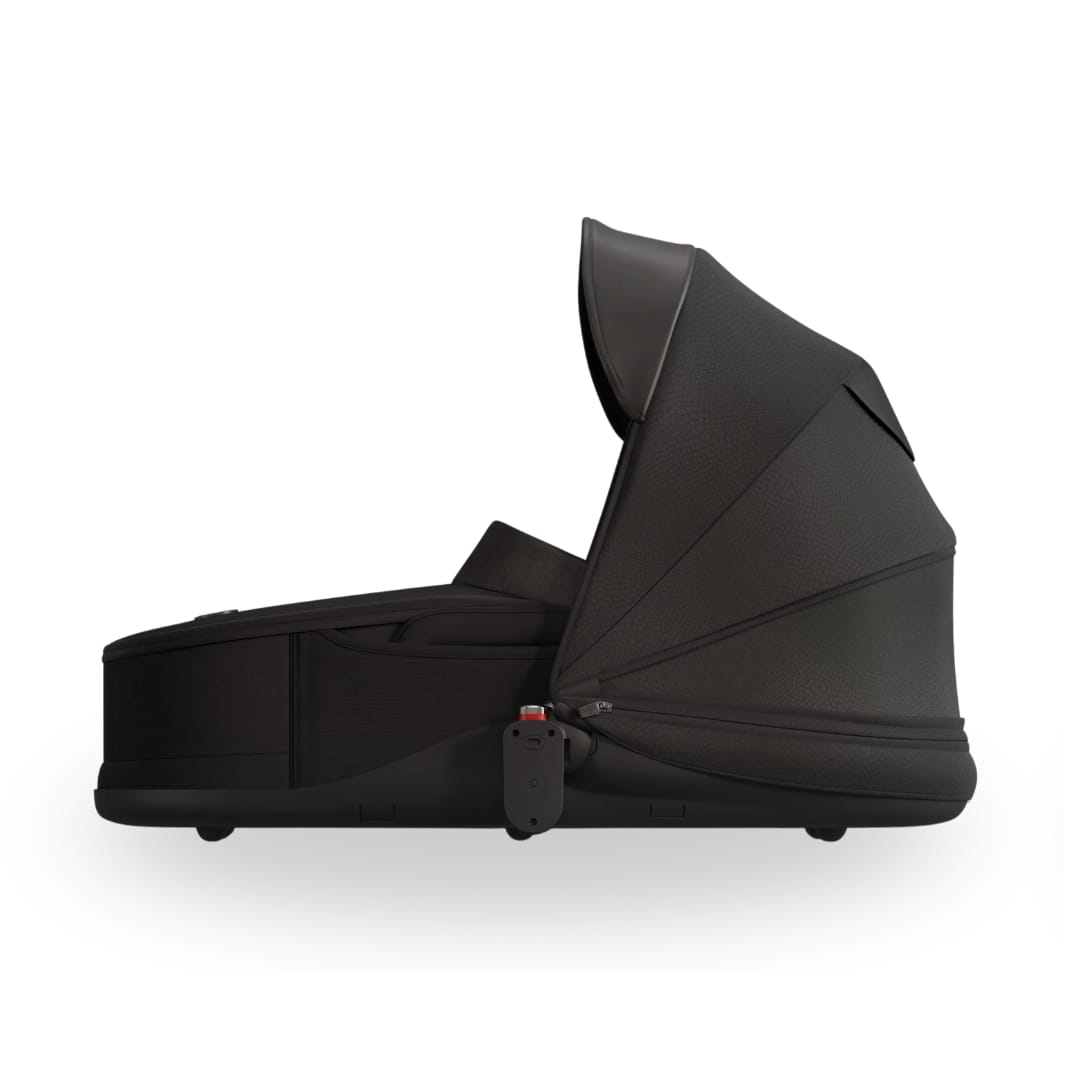 Black Mima carrycot with extended canopy viewed from the side
