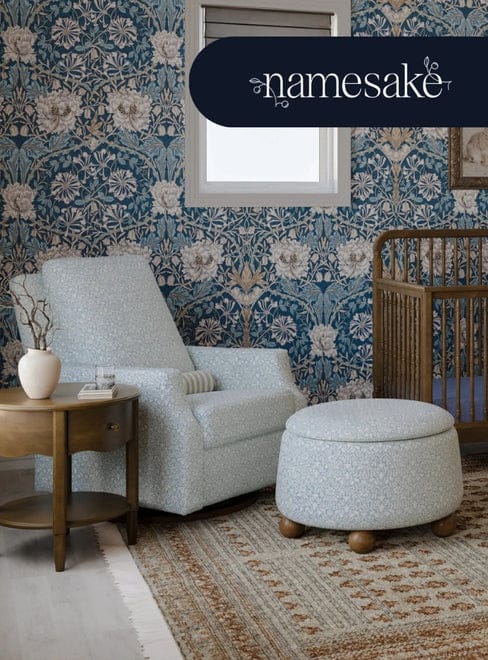 A baby's room with floral wallpaper, a light-blue chair, ottoman, side table, and a crib. "Namesake" text is visible above the window.