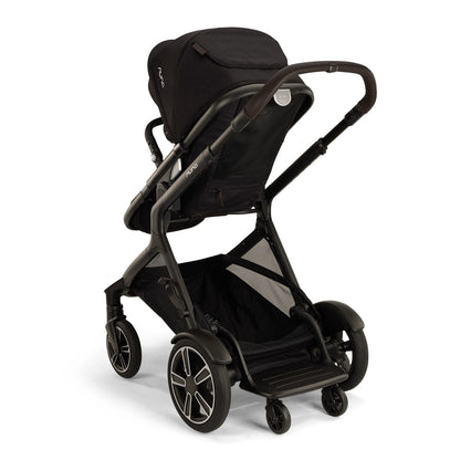 Nuna black stroller viewed from the rear showing the storage basket and wheels