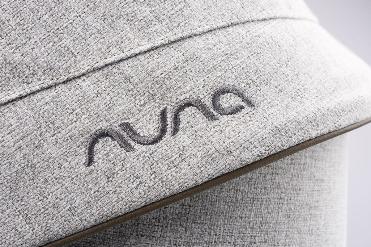Nuna logo embroidered on light grey textured fabric