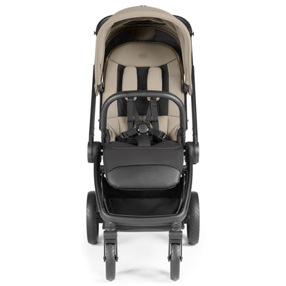 Front view of a beige and black PEG stroller with a five point harness
