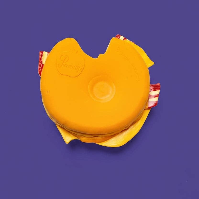 Piccolini rubber burger dog toy with a bite mark on a purple background