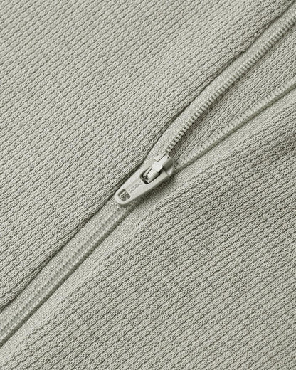 Close up of a Quincy Mae sage green textured fabric with a matching zipper