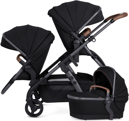 Black single-to-double stroller with matching carrycot and seat unit, by Silver Cross, featuring brown leatherette handles and mesh storage basket, shown in side view.