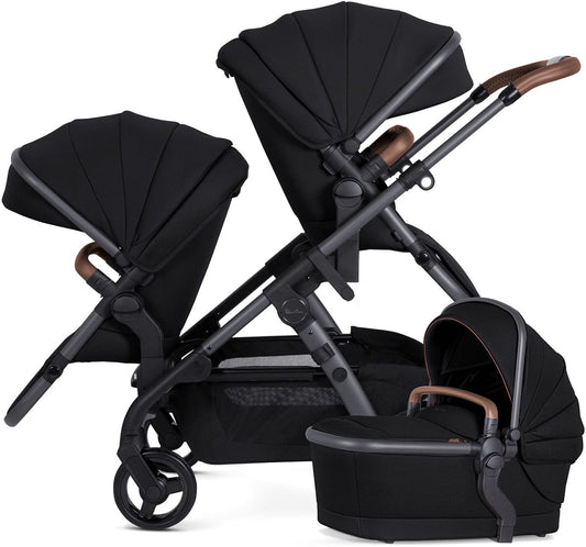 Black single-to-double stroller with matching carrycot and seat unit, by Silver Cross, featuring brown leatherette handles and mesh storage basket, shown in side view.