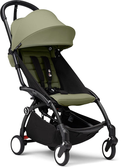 Black and olive green compact stroller by Stokke, featuring padded seat, adjustable canopy, and four wheels, side view.